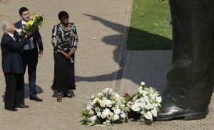 George Bizos (izquierda), abogado de derechos humanos que trabajó para el fallecido ex presidente de Sudáfrica Nelson Mandela, hace una ofrenda floral ante una estatua de bronce de nueve metros con la imagen del mandatario en el primer aniversario de su muerte. Foto: AP
