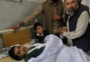 Un paquistaní consuela a un estudiante de pie junto a la cama de un niño herido en un atentado talibán sobre una escuela, en un hospital de Peshawar, Paquistán. Foto: AP