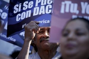 Un hombre aparece entre carteles durante una manifestación en apoyo del plan del presidente Barack Obama para proteger de la deportación a más de cuatro millones de personas que viven en Estados Unidos sin permiso. Foto: AP