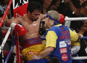 Manny Pacquiao, left, listens to trainer Freddie Roach between rounds of his welterweight title fight against Floyd Mayweather Jr. on Saturday, May 2, 2015 in Las Vegas. (AP Photo/Eric Jamison)