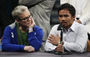 FILE - In this May 2, 2015 photo, trainer Freddie Roach, left, listens as Manny Pacquiao answers questions during a press conference following his welterweight title fight against Floyd Mayweather Jr. in Las Vegas. Pacquiao could face disciplinary action from Nevada boxing officials for failing to disclose a shoulder injury before the fight. Nevada Athletic Commission Chairman Francisco Aguilar said that the state attorney general’s office will look at why Pacquiao checked “no” a day before the fight on a commission questionnaire asking if he had a shoulder injury. (AP Photo/John Locher)