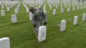 Third U.S. Infantry Regiment (The Old Guard) Pfc. Kaitlyn Bolde of Scotia, N.Y., places a flag in front of a headstone at Arlington National Cemetery in Arlington, Va., Thursday, May 21, 2015."Flags In" is an annual tradition that is reserved for The Old Guard since its designation as the Army’s official ceremonial unit in 1948. They conduct the mission annually at Arlington National Cemetery and the U.S. Soldiers' and Airmen's Home National Cemetery prior to Memorial Day to honor the nation’s fallen military heroes. (AP Photo/Susan Walsh)
