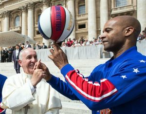 El papa Francisco sonríe mientras el jugador de los Harlem Globetrotters, Flight Time Lang, le enseña cómo sostener el balón con un dedo. Foto: AP