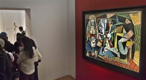 El óleo de Pablo Picasso "Las mujeres de Arhel (Versión O)" es exhibido el 1 de mayo de 2015 en un tipo de galería antes de que la sacara a la venta la casa de subastas Christie's, en Nueva York. El cuadro se vendió en 179 millones de dólares, una cantidad sin precedentes para una obra de arte vendida en subasta, el lunes 11 de mayo de 2015. Al fondo a la derecha es mostrada una escultura de bronce de tamaño natural "Hombre señalando", del suizo Alberto Giacometti, que Christie's también podría a subasta. (AP Foto/Bebeto Matthews)