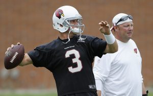 Arizona Cardinals' Carson Palmer (3) throws a pass as quarterbacks coach Freddie Kitchens, right, looks on during an NFL football organized team activity, Tuesday, June 9, 2015, in Tempe, Ariz. (AP Photo/Ross D. Franklin)