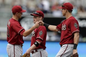 Arizona Diamondbacks' Nick Ahmed, left, celebrates with teammates Jake Lamb, right, and Aaron Hill, center, after defeating the San Diego Padres in a baseball game Sunday, June 28, 2015, in San Diego. The Diamondbacks won 6-4. (AP Photo/Gregory Bull)