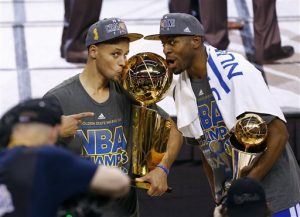 Stephen Curry, de los Warriors, besa el trofeo junto a su compañero Andre Iguodala, luego de que el equipo se coronó en la final de la NBA. Foto: AP