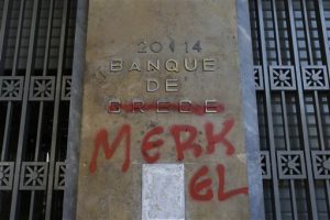 Pintura roja cubre las palabras Banco de Grecia para que se lea “Banco de Merkel” en referencia a la canciller alemana, en Atenas. Foto: AP