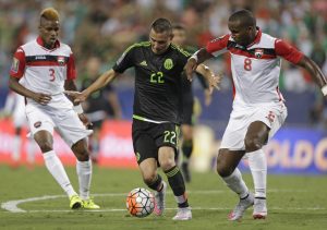 Mexico’s Paul Aguilar (22) drives between Trinidad & Tobago’s Khaleem Hyland (8)  and Joevin Jones (3) during the first half of a CONCACAF Gold Cup soccer match in Charlotte, N.C., Wednesday, July 15, 2015. (AP Photo/Gerry Broome)