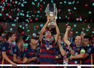 Barcelona's Sergio Busquets lifts the trophy after winning the UEFA Super Cup soccer match between FC Barcelona and Sevilla FC at the Boris Paichadze Dinamo Arena stadium, in Tbilisi, Georgia, on Wednesday, Aug. 12, 2015. Barcelona won 5-4. (AP Photo/Ivan Sekretarev)