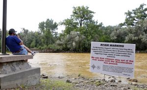 Un letrero advierte a las personas que no se metan al río Animas en lo que dura la coloración amarillenta y naranja del río a causa de un derrame de aguas residuales de una mina antigua en el parque Berg, en la localidad de Farmington, Nuevo México. Foto: AP