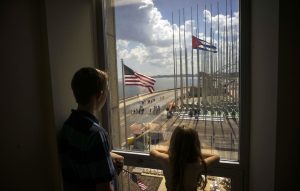 Dos niños contemplan desde la ventana de su casa las banderas de EU y Cuba a unos metros del malecón habanero. Foto: AP 