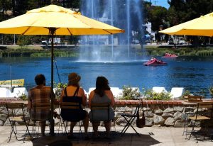 Visitantes del Echo Park Lake cerca del centro de Los Angeles se protegen del fuerte sol el viernes 14 de agosto de 2015. (Foto AP/Richard Vogel)