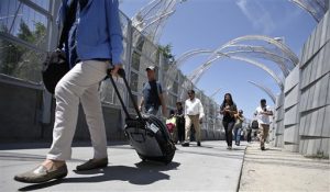 peatones cargan con maletas y otros bienes por el nuevo paso fronterizo de México en San Ysidro, California. Foto: AP