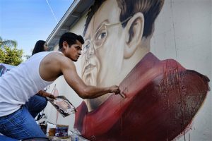 Levi Ponce pinta un retrato de Diego Rivera en un muro del barrio Pacoima de Los Angeles. Foto: AP