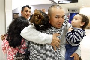 Gabriel Mejía abraza a su hija Wendy, de 16 años, mientras sostiene en un brazo a su hijo Elías, de un año, en el aeropuerto de Baltimore. Foto: AP