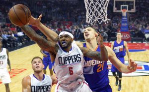 Los Angeles Clippers forward Josh Smith, center, grabs a rebound away from Phoenix Suns center Alex Len, right, of Ukraine, as forward Blake Griffin, lower left, watches during the first half of an NBA basketball game, Monday, Nov. 2, 2015, in Los Angeles. (AP Photo/Mark J. Terrill)