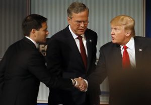 Marco Rubio y Donald Trump se estrechan la mano junto a Jeb Bush durante el debate de aspirantes a al candidatura republicana a la presidencia. Foto: AP
