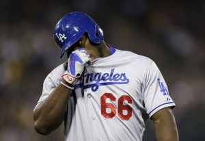 Los Angeles Dodgers' Yasiel Puig wipes his face after hitting a fly out against the Oakland Athletics in the sixth inning of a baseball game Tuesday, Aug. 18, 2015, in Oakland, Calif. (AP Photo/Ben Margot)