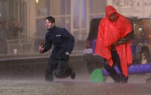 Varias personas corren bajo un aguacero en medio del sonido de sirenas que advierten sobre una tormenta en el centro de Dallas, Texas, el sábado 26 de diciembre. Foto: AP
