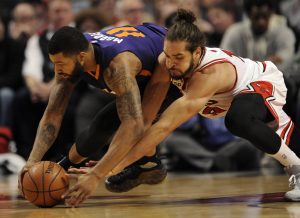 Chicago Bulls' Joakim Noah (13), battles Phoenix Suns' Markieff Morris (11), for a loose ball during the first half of a basketball game Monday, Dec. 7, 2015, in Chicago. (AP Photo/Paul Beaty)