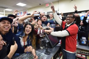 El dependiente de una tienda 7-Eleven M. Faroqui celebra con clientes la noticia sobre que la tienda vendió un boleto ganador en la lotería Powerball en Chino Hills, California. Foto: AP