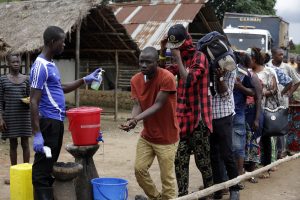 Un hombre toma la temperatura de la gente y ayuda a lavarles las manos al dejar el área de cuarentena por ébola luego de que el presidente de Sierra Leona, Ernest Bai Koroma, cortara el listón para liberar de la cuarentena a la aldea Massessehbed en las afueras de Freetown, Sierra Leona. Foto: AP