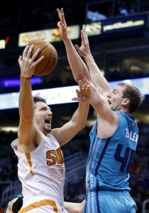 El bosnio Mirza Teletovic, de los Suns de Phoenix, dispara junto a Cody Zeller, de los Hornets de Charlotte, en el duelo realizado el miércoles. Foto: AP