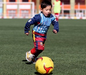 Martaza Ahmadi, un niño afgano de cinco años seguidor del futbolista Lionel Messi, juega al fútbol en el estadio de la federación afgana de fútbol en Kabul, Afganistán, el martes 2 de febrero de 2016. (AP Foto/Rahmat Gul)