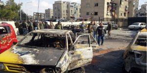 En esta fotografía difundida por la agencia de noticias oficial siria, SANA, soldados y policías no uniformados se reúnen en el lugar de una explosión que al menos a 10 personas e hirió a otras en la capital siria Damasco, el martes 9 de febrero de 2016. El grupo Estado Islámico se atribuyó el ataque suicida que causó mucho daño material a edificios y autos en la zona. El grupo EI juró perpetrar más ataques en el futuro. (SANA vía AP)