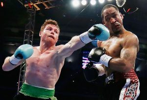 HOUSTON, TX - MAY 09:  Canelo Alvarez of Mexico (L) delivers a punch to James Kirkland during their super welterweight bout at Minute Maid Park on May 9, 2015 in Houston, Texas.  (Photo by Scott Halleran/Getty Images)