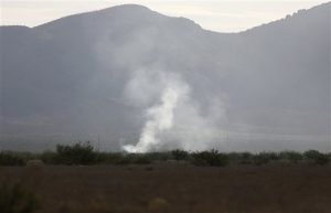 Una columna de humo se alza desde el sitio en el que se estrelló un aviòn de combate F-16 el miércoles por la noche cerca de Douglas. Foto: AP