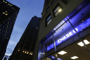 The lights are on at a branch of Chase Bank, Wednesday, Jan. 14, 2015 in New York.  JPMorgan Chase reported a 7 percent drop in fourth-quarter earnings Wednesday, hit by more legal costs and a drop in trading revenue. JPMorgan, the biggest U.S. bank by assets, said it earned $4.93 billion, or $1.19 a share, for the three-month period ending in December. (AP Photo/Mark Lennihan)