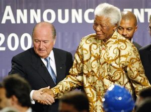 En esta imagen del 5 de mayo de 2004, el ex presidente de Suráfrica, Nelson Mandela es acompañado del presidente de FIFA, Sepp Blatter, a la izquierda, en Zurich, Suiza, donde se anunció a Suráfrica como el país sede de la Copa del Mundo de 2010. 