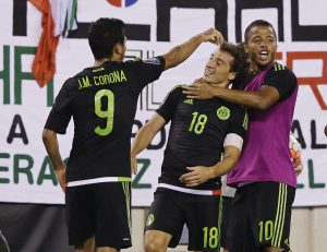 Mexico's Andres Guardado (18) celebrates scoring a goal with teammates Giovani Dos Santos, right, and Jesus Corona, left, during the overtime period of a CONCACAF Gold Cup soccer match Sunday, July 19, 2015, at MetLife stadium in East Rutherford, N.J. Mexico won 1-0. (AP Photo/Mel Evans)