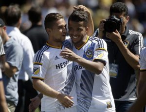 Los Angeles Galaxy's Giovani Dos Santos, right, and Ignacio Maganto celebrate the team's 3-1 win against the Seattle Sounders in an MLS soccer match, Sunday, Aug. 9, 2015, in Carson, Calif. (AP Photo/Jae C. Hong)
