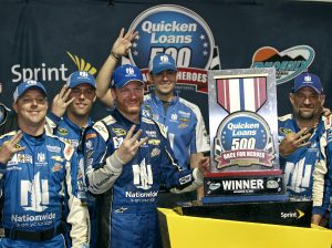 Dale Earnhardt Jr., center left, and his pit crew celebrate their third victory of the season after winning the the NASCAR Sprint Cup Series auto race at Phoenix International Raceway, Sunday, Nov. 15, 2015, in Avondale, Ariz. Earnhadrt was leading on lap 219 when the race was called due to rain. (AP Photo/Ralph Freso)