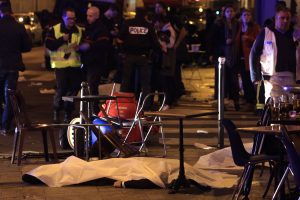 Una víctima yace en el pavimento afuera de un restaurante de París el viernes por la noche. Foto: AP