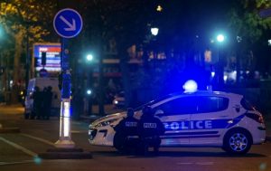 Agentes de la policía se cubren detrás de vehículos afuera del teatro Bataclan en París, Francia, el pasado viernes. Foto: AP