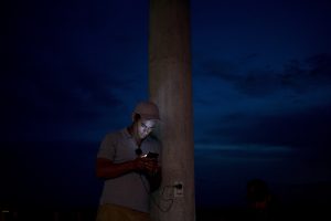 El migrante cubano Yannier Rodríguez observa su teléfono celular en La Cruz, Costa Rica, cerca de la frontera con Nicaragua. Foto: AP