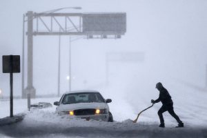 Un conductor retira la nieve para abrir paso a un vehículo en el tramo carretero New Jersey Turnpike durante una tormenta de nieve el pasado sábado en Port Reading, New Jersey. Foto: AP