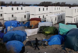 Migrantes caminan en un campamento improvisado en Calais, en el norte de Francia. Miles de migrantes corren ahora más peligro luego de que varios gobiernos de la Unión Europea adoptaron medidas para frenar su entrada a la región. Foto: AP
