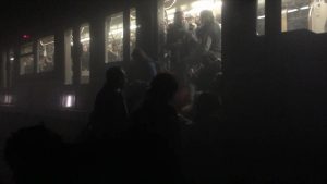 En esta foto proporcionada por Evan Lamos, pasajeros se suben a un vagón del metro después de explosiones en Bruselas el martes 22 de marzo de 2016. Bélgica está en su máxima alerta de seguridad, desviando aviones por aterrizar y trenes, y pidiendo a la gente que no se mueva de donde están. (Evan Lamos vía AP)