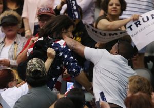 Bryan Sanders, manifestante contrario a Donald Trump, centro, es golpeado por un partidario del precandidato presidencial republicano durante un acto de campaña en la Tucson Arena, en el centro de Tucson, Arizona, el sábado 19 de marzo de 2016. (Mike Christy/Arizona Daily Star vía AP)